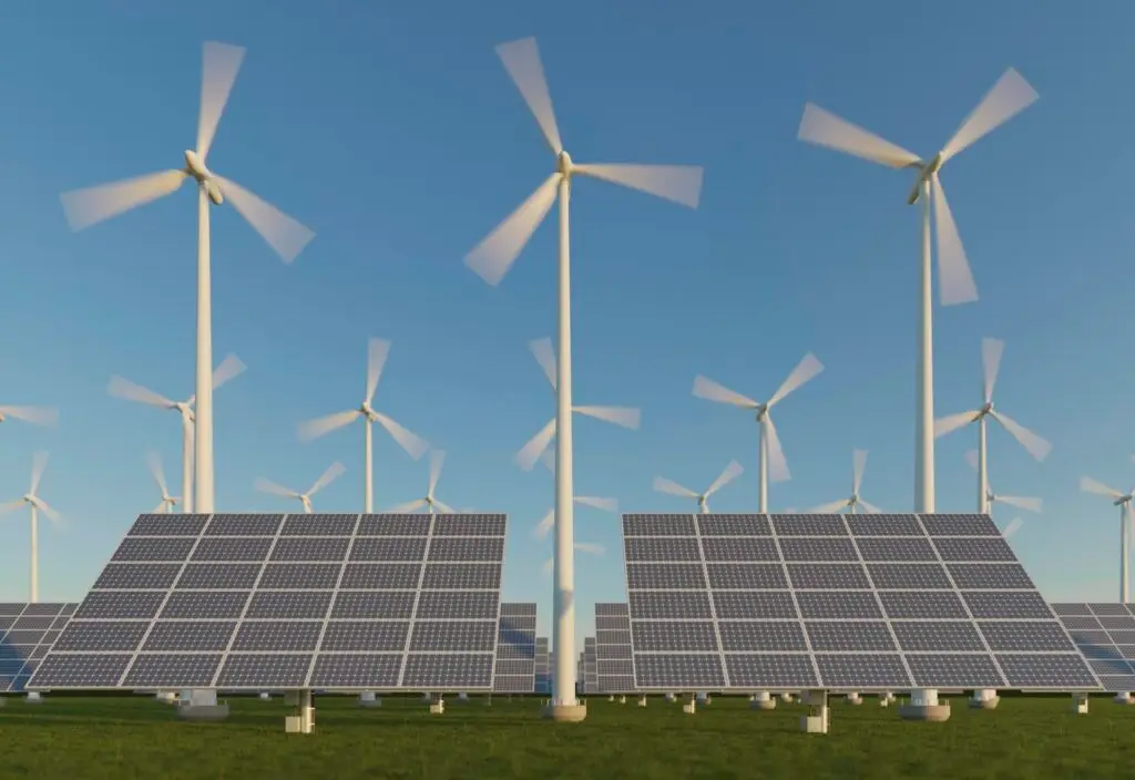 No gramado, fileiras de painéis solares captam a luz do sol, enquanto turbinas eólicas giram ao fundo sob um céu azul, mostrando como os sistemas híbridos funcionam na geração inovadora de energia renovável.