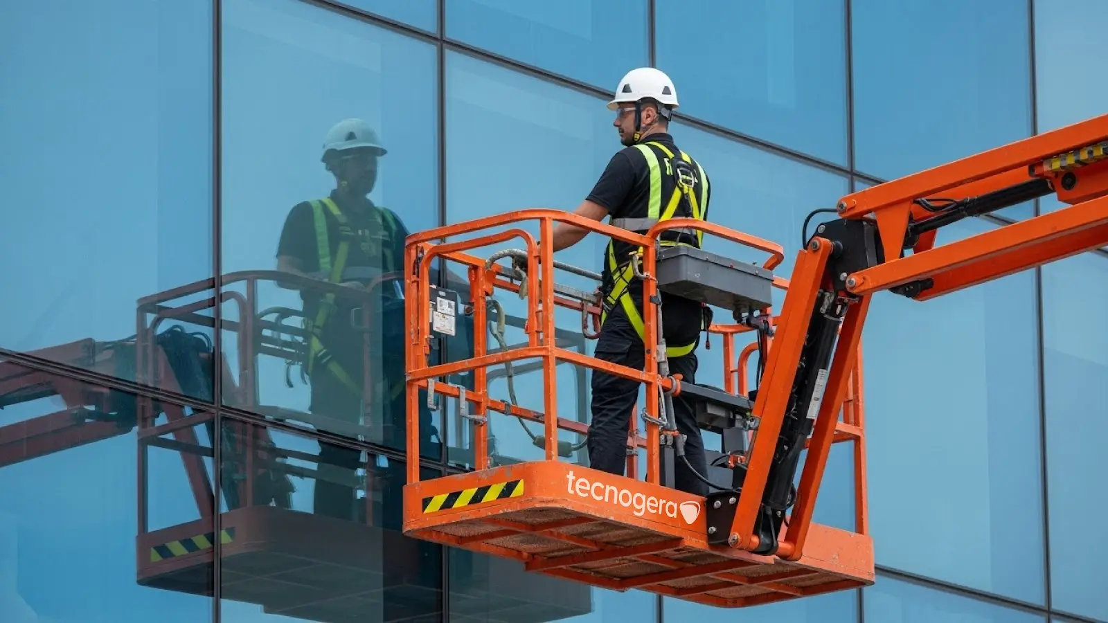 Técnicos em plataforma elevatória da Tecnogera em fachada